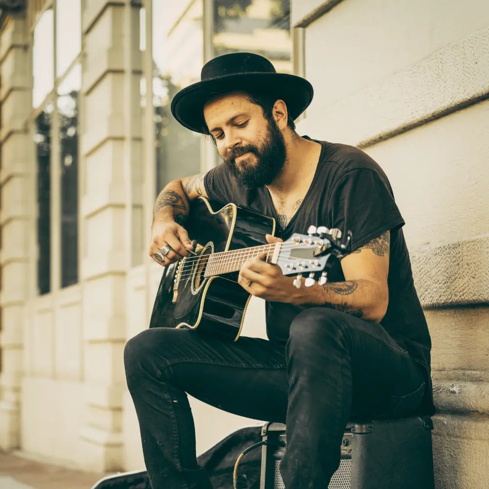 Grassroots EP promotion thrives on street performances, as seen in this busker playing guitar on a city sidewalk.