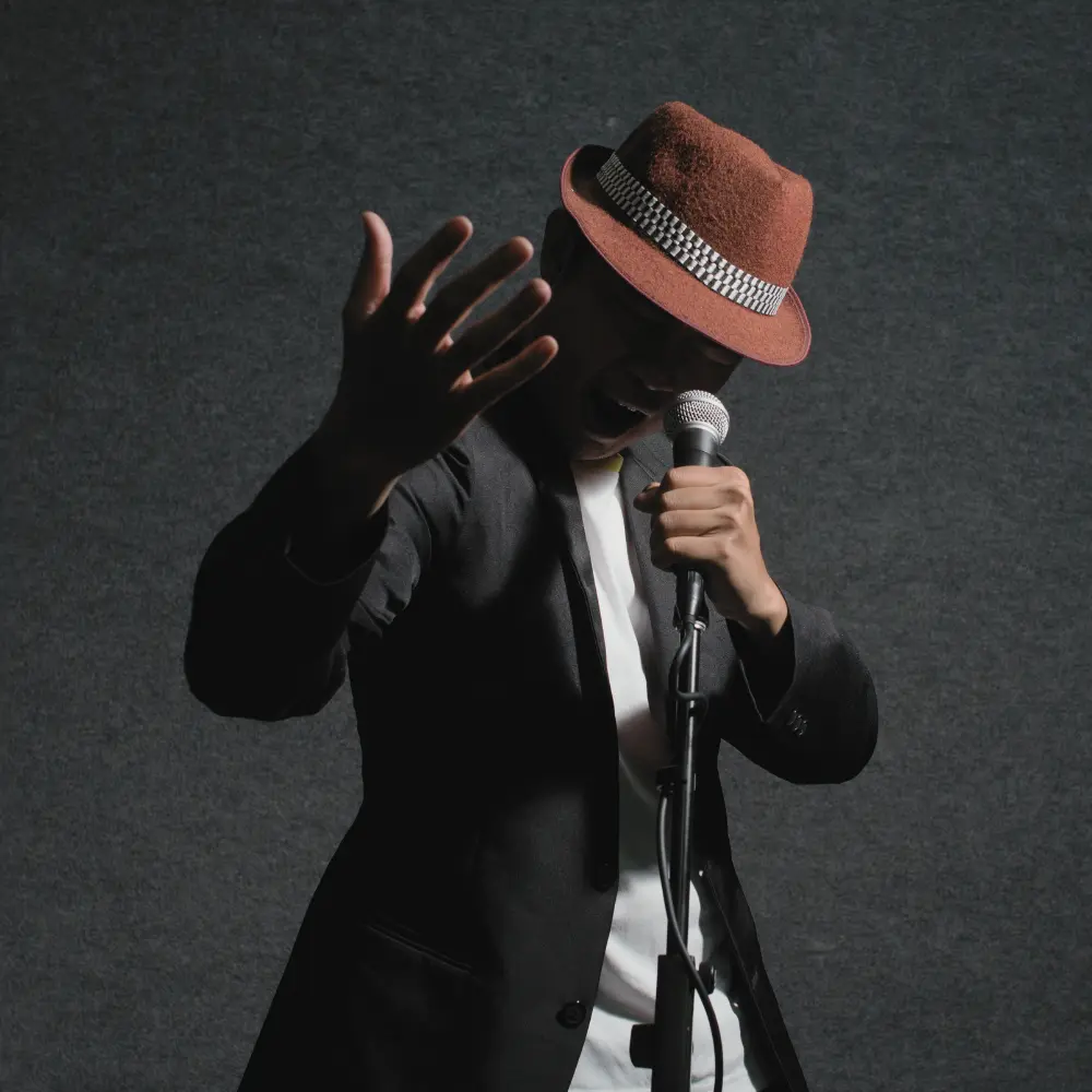 A passionate singer in a fedora performs with a microphone, representing opportunities in music publishing.