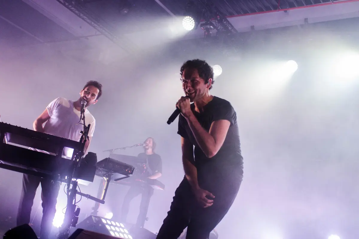 Launch music on Apple Music with a strong live performance, as shown by this energetic band on stage under dramatic lighting.