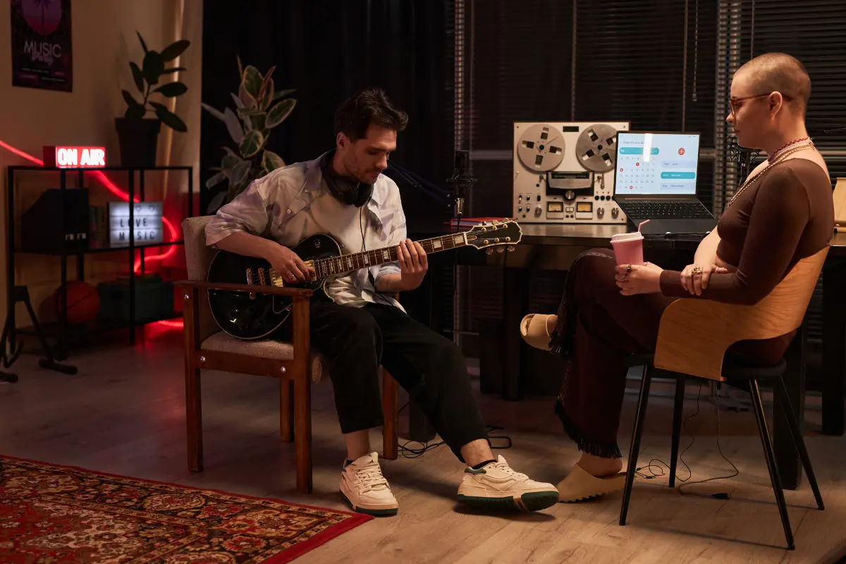 A guitarist and a music producer discussing strategies for using music distribution platforms in a professional studio.