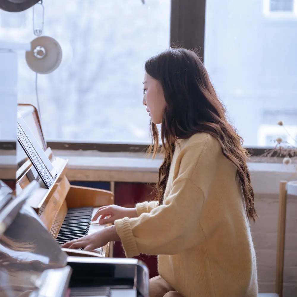 New artists' music publishing can start with songwriting, as seen in this pianist composing music by a window