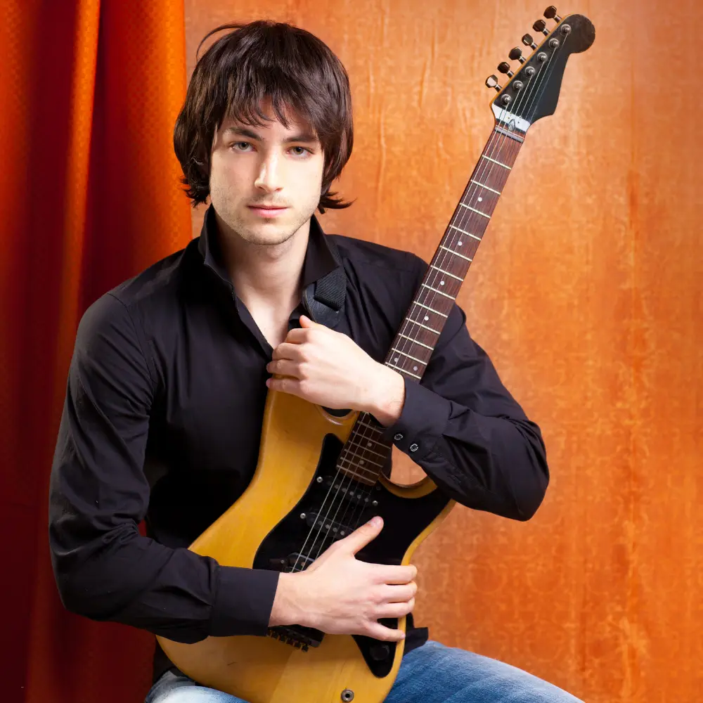 A musician holding an electric guitar, symbolizing independent artists self-publishing music online without a record label.