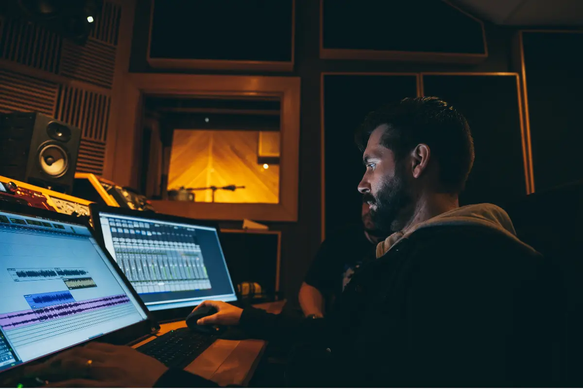 sync licensing for musicians depicted with a producer mixing tracks in a professional recording studio.