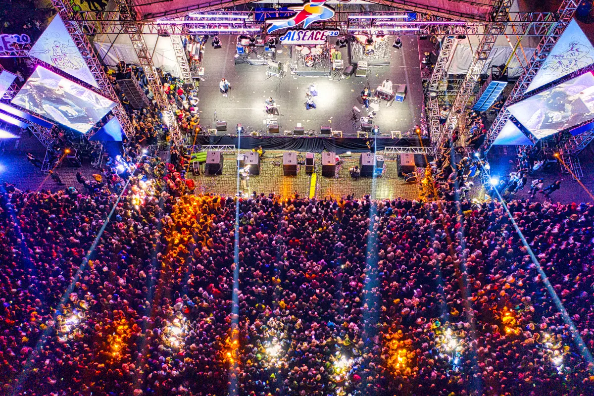 Independent music marketing illustrated by a large crowd attending a high-energy live concert under colorful stage lights