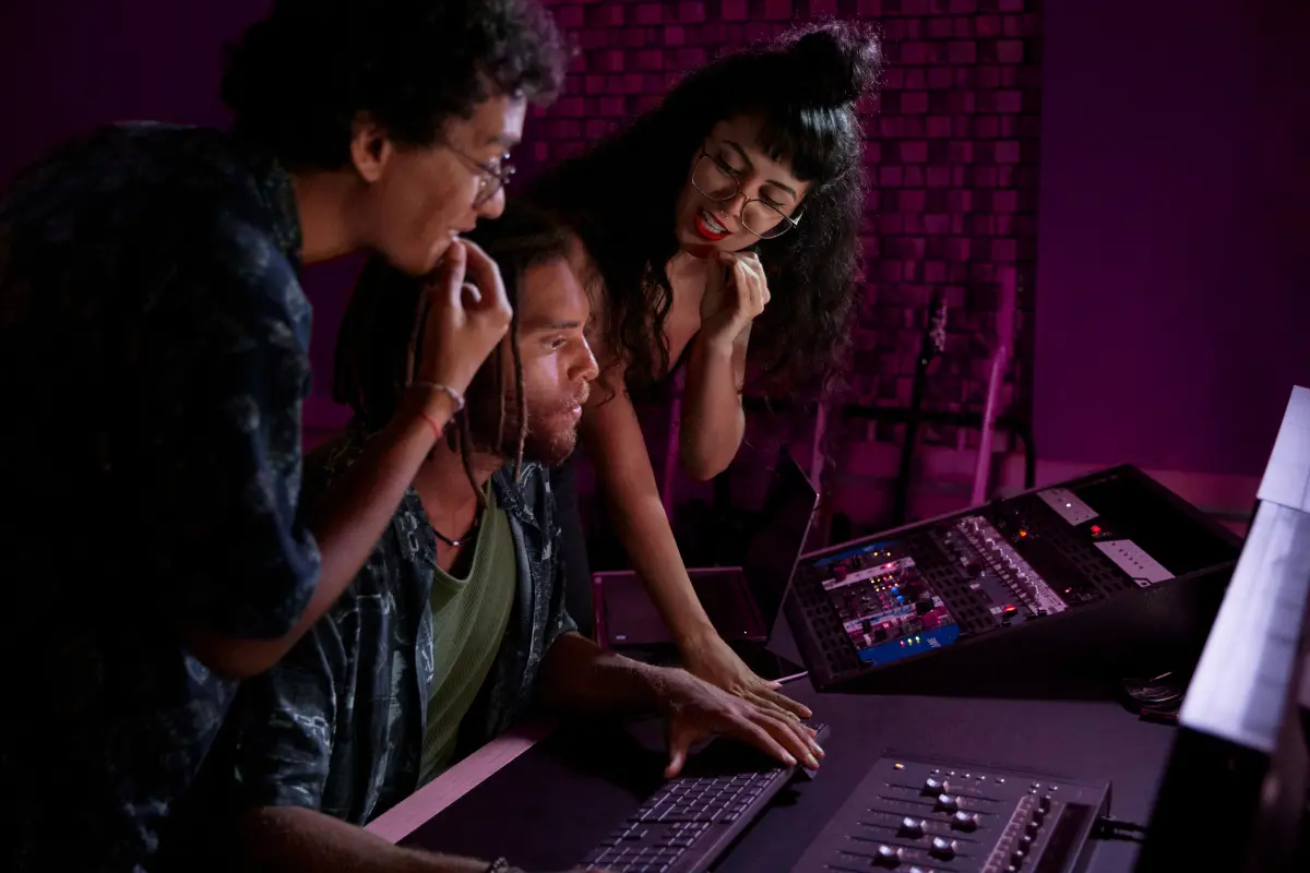 Self-publishing for musicians depicted by a focused team editing tracks in a modern audio production studio