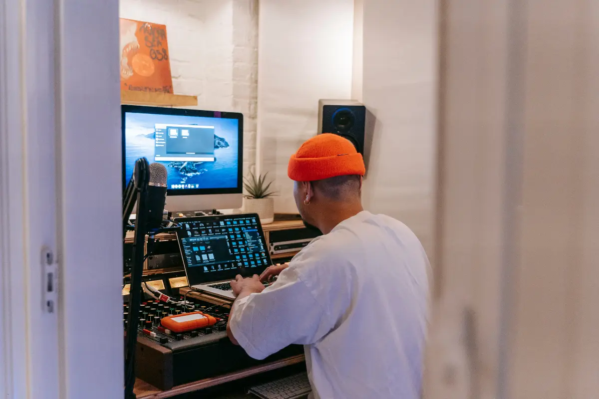 Virtual music studios illustrated by a producer working at a digital audio workstation with multiple screens
