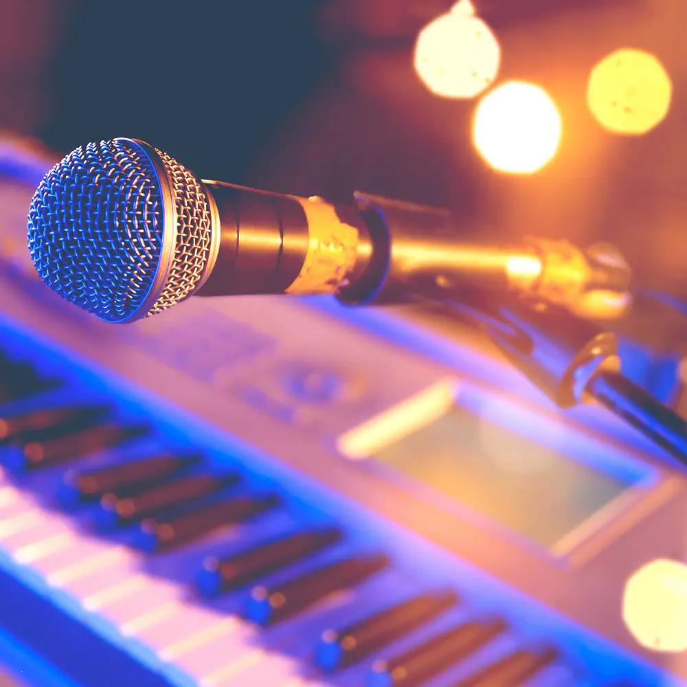 Music portfolio performance gear with microphone and digital keyboard under stage lighting.